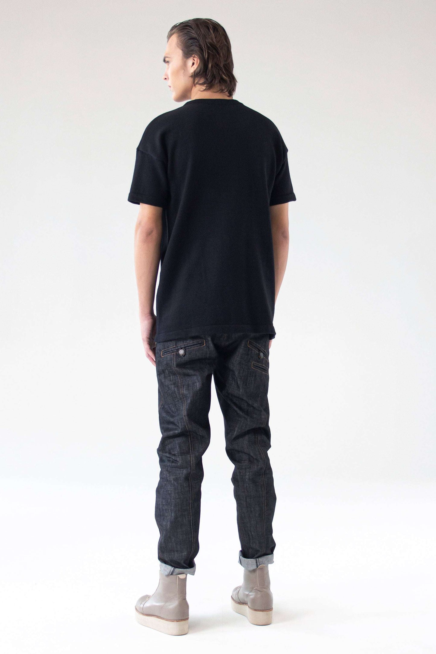 Back view of the One Wolf Knitted T-Shirt SEEKER in black, showing clean seams and relaxed unisex fit.